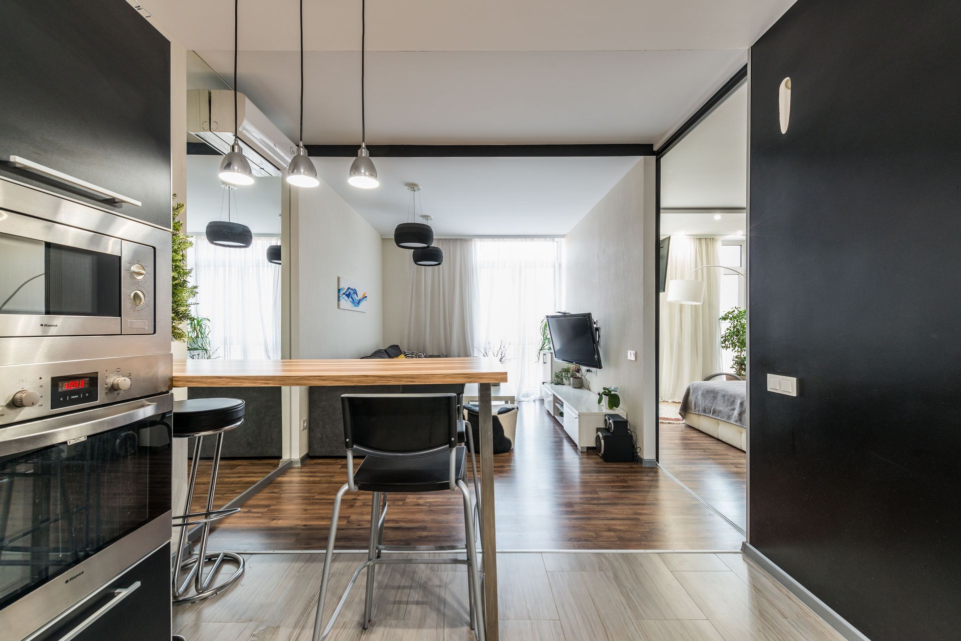 Interior of contemporary apartment with kitchen zone and slider doors separating living room and bedroom